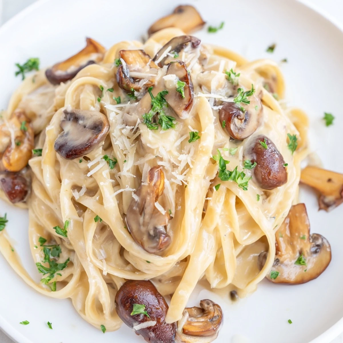 Golden-brown sautéed mushrooms and al dente linguine tossed in a creamy Parmesan sauce, garnished with fresh parsley.  