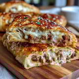 Warm pigs in a blanket wrapped in flaky puff pastry, served with a tangy mustard dip for the perfect game day appetizer.