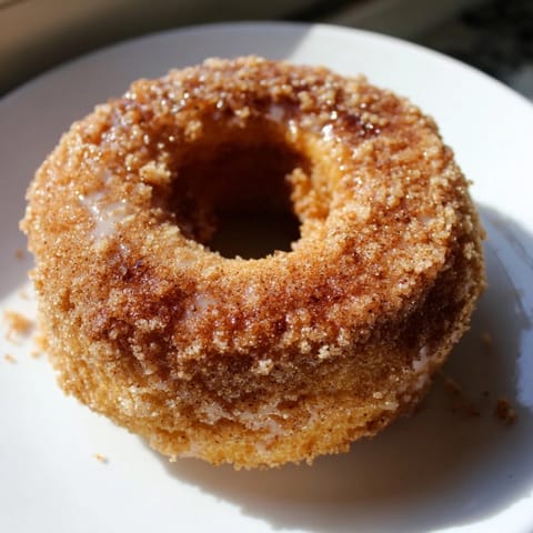 A close-up of golden brown cinnamon-sugar baked donuts with a sweet coating and inviting texture.