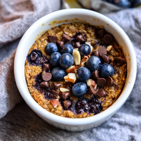 A close-up of golden blueberry baked oats, fluffy and studded with juicy blueberries, ready to serve.