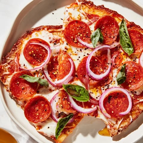 A close-up of a bubbling hot honey pepperoni flatbread, ready for slicing and enjoying.