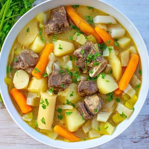 Savory, hearty Welsh Cawl stew, with carrots and potatoes, perfect for a cozy, comforting meal.