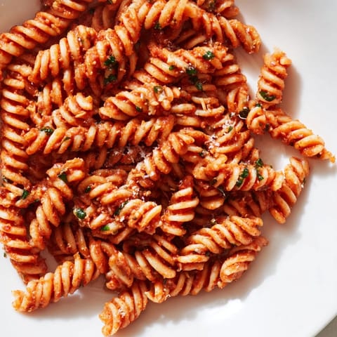 Hearty plate of Sun-Dried Tomato Pesto Pasta tossed with penne, topped with grated Parmesan and a drizzle of golden olive oil.  