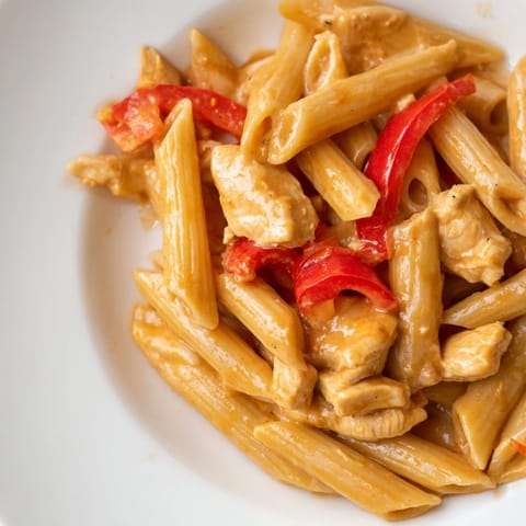 Tender chicken and fusilli pasta coated in a glossy sweet chili sauce with red bell peppers and spring onions.