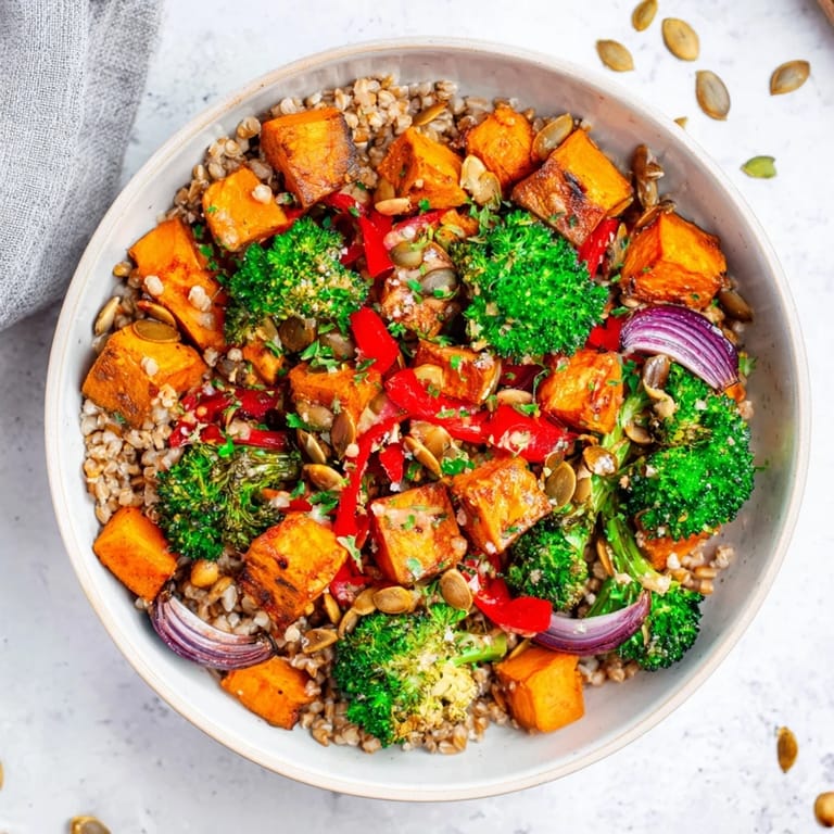 A delicious Hearty Roasted Vegetable and Farro Grain Bowl, warm and drizzled with a creamy tahini dressing.