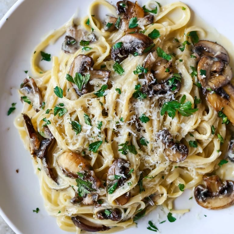 Tender mushrooms nestled in silky cream sauce over linguine, served with extra shaved Parmesan.