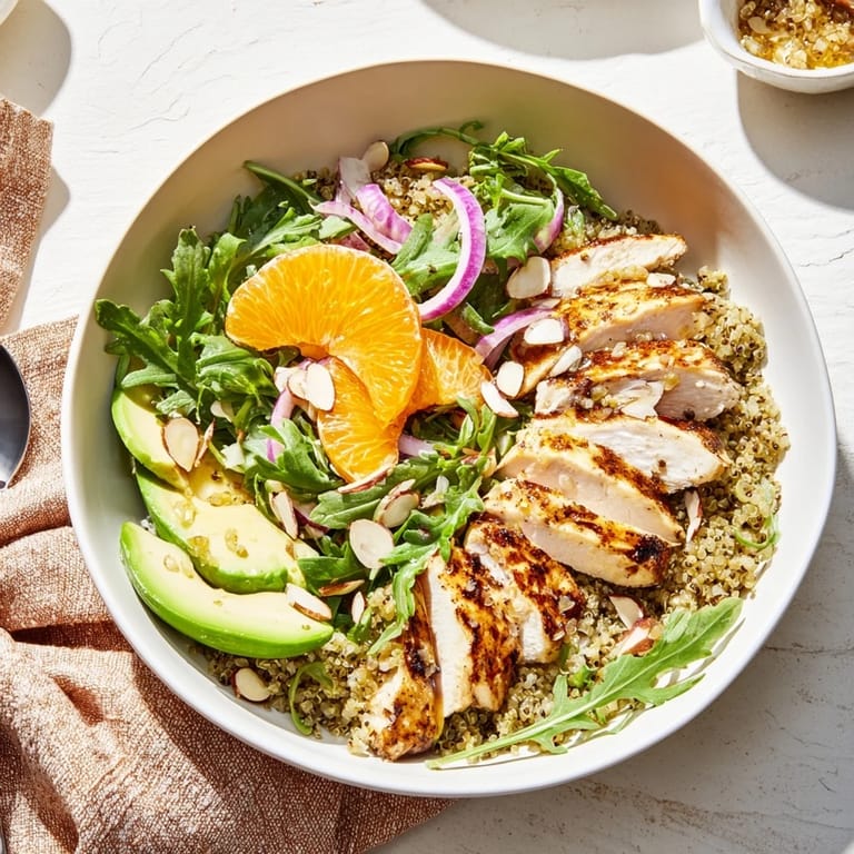 A wholesome, fresh meal prep bowl features juicy grilled chicken, crisp greens, and avocado over quinoa, finished with a zesty citrus vinaigrette for this Citrus Herb Chicken Salad Bowl.