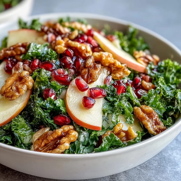 A fresh Kale and Pomegranate Bowl tossed with olive oil dressing and ready to serve on a rustic table.