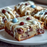 Colorful graduation cookie bars with chocolate chips and white chocolate drizzle, perfect for celebrating achievements.